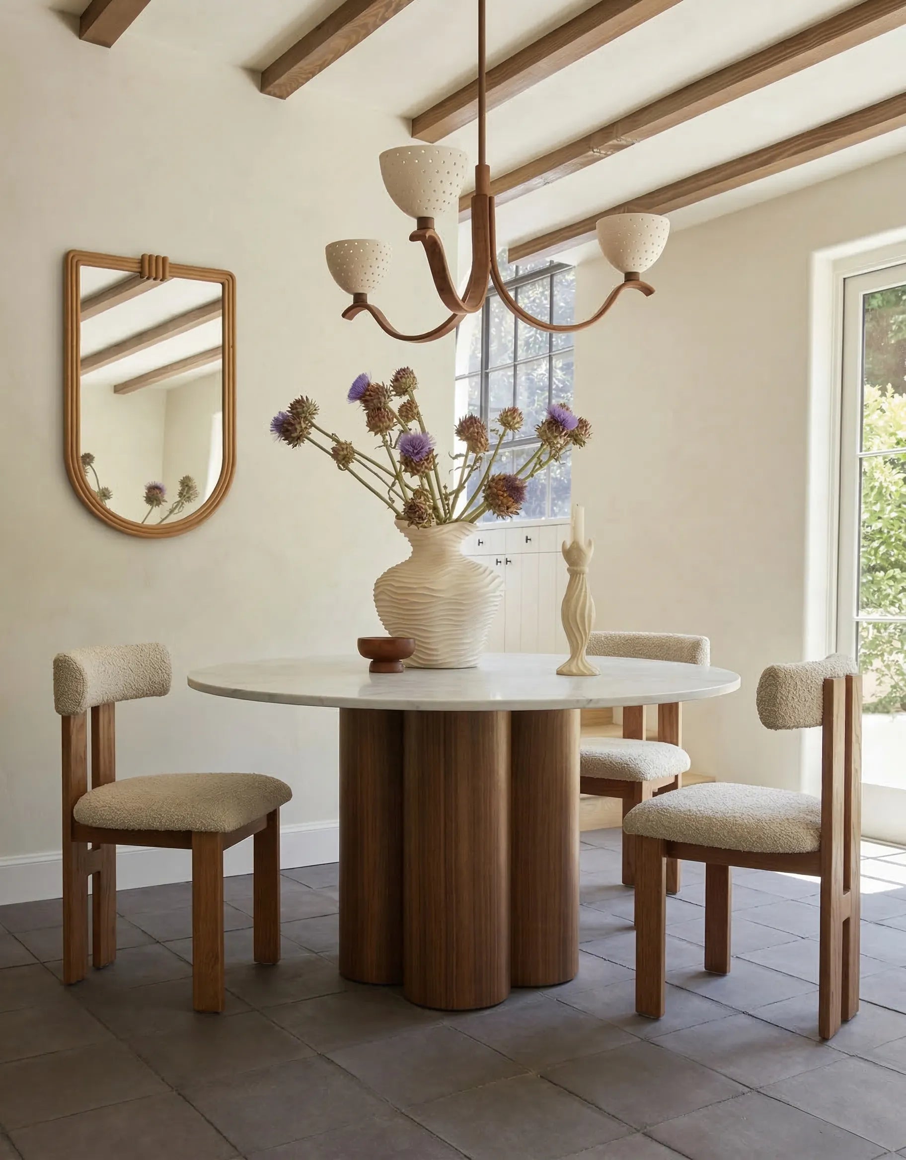 Carrara marble top walnut base round dining table styled in modern dining room