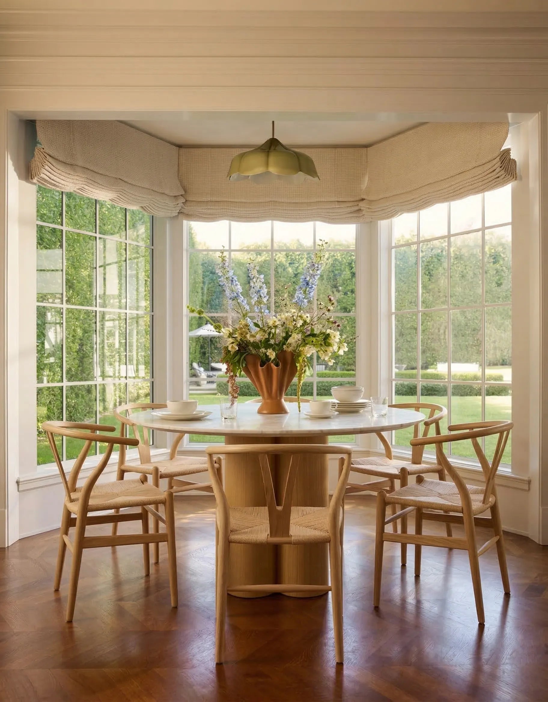 Round Carrara marble dining table in bright sunroom dining space