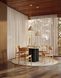 Black ash and natural oak round wooden dining table styled in dining room