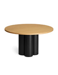 Round wooden table with black cylindrical legs and natural oak table top