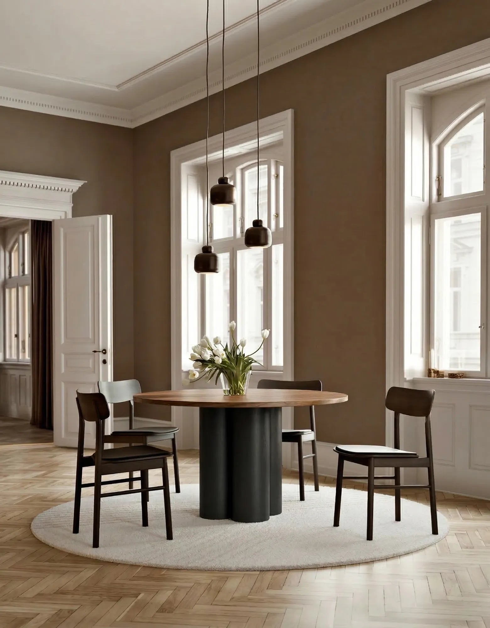 Dining room with a round wooden table with walnut top and black ash base